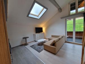 ein Wohnzimmer mit Sofa und Fernseher in der Unterkunft Saaner Valley Home in Boltigen