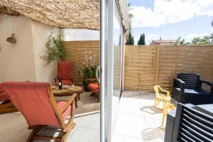a patio with a table and chairs and a fence at Maison classée 3étoiles proche plage in Mauguio