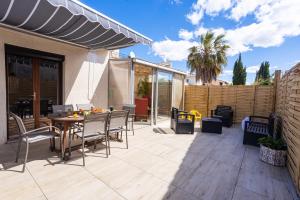 un patio con mesa, sillas y una valla en Maison familiale 2ème ligne - places de parking en Mauguio