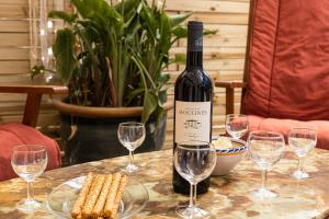una bottiglia di vino seduta su un tavolo con bicchieri da vino di Maison familiale 2ème ligne - places de parking a Mauguio