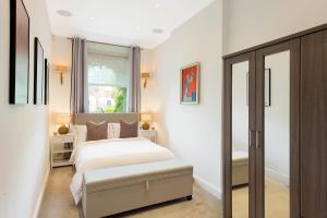 a bedroom with a large bed and a window at Beautiful Regents Park Apartment in London