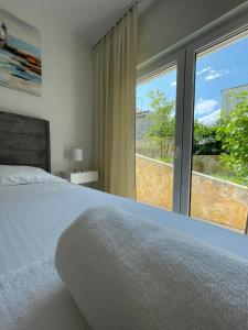 a bedroom with a bed and a large window at Apartment Tina, Modern, Private SeaView Outdoor Terrace, BBQ, close to beach, 2 bedrooms in Trogir