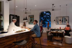 two men sitting at a bar in a restaurant at Villa Paranaguá Hotel & Spa - Boutique Hotel in Rio de Janeiro