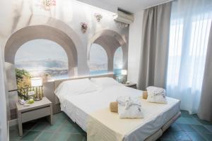 een slaapkamer met 2 bedden en 2 ramen bij Hotel L'Approdo in Castiglione della Pescaia