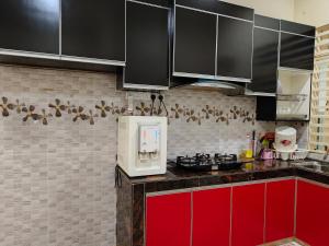 a kitchen with red cabinets and a microwave at HOMESTAY NOVA in Kuala Terengganu