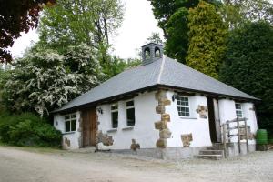 um pequeno edifício branco com um telhado íngreme em Bosinver Farm Cottages Well Close em St Austell