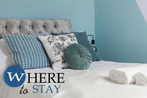 Una cama con almohadas azules y blancas. en Elegant 4bed House-FREE parking, en Barrow-in-Furness