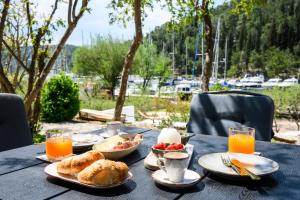 a table with plates of food and drinks on it at Mila and Jurija Formenti 2 apartments in heart of nautic marina, with heated swimming pool, bikes, Sup, kajak in Skradin