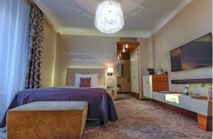 ein Hotelzimmer mit einem Bett und einem Flachbild-TV in der Unterkunft Hotel Schweizerhof Luzern in Luzern