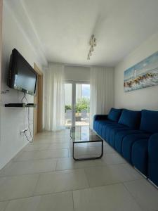 a living room with a blue couch and a tv at Apartment Tina, Modern, Private SeaView Outdoor Terrace, BBQ, close to beach, 2 bedrooms in Trogir