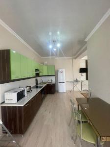 a large kitchen with green cabinets and a white refrigerator at 1 bedroom Seaside apartments in Green Park 1 комнатная квартира in Aktau