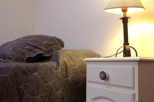 una lámpara en una mesita de noche junto a una cama en La Morada - Dean Funes en Salta
