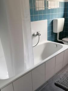 a white bath tub in a bathroom with a toilet at Helle 3 Zimmer Wohnung in Krefeld
