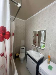 y baño con lavabo, aseo y espejo. en 1 bedroom Seaside apartments in Green Park 1 комнатная квартира, en Aktau