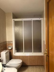 a bathroom with a toilet and a window at Apartamento a 20 metros de la playa in Calafell