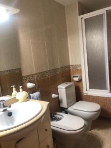卡拉費爾的住宿－Apartamento a 20 metros de la playa，浴室配有白色卫生间和盥洗盆。
