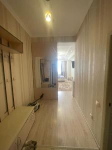 una stanza vuota con cucina e pavimento in legno di 1 bedroom Seaside apartments in Green Park 1 комнатная квартира ad Aqtau