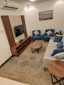 a living room with a couch and a tv at نسناس للأجنحة الفندقية in Namirah