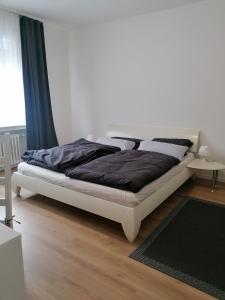ein Schlafzimmer mit einem Bett in einem weißen Zimmer in der Unterkunft Helle 3 Zimmer Wohnung in Krefeld
