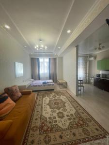 een woonkamer met een bank en een bed bij 1 bedroom Seaside apartments in Green Park 1 комнатная квартира in Aqtau