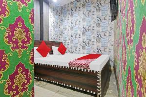 a bedroom with a bed with red pillows on it at OYO Hotel Dream Town 2 in New Delhi