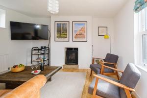 a living room with a tv and a fireplace at Frogmore Cottage in Leiston