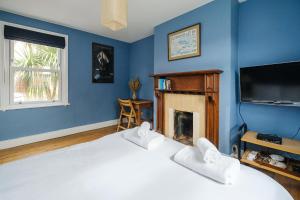 a bedroom with a bed and a tv and a fireplace at Frogmore Cottage in Leiston