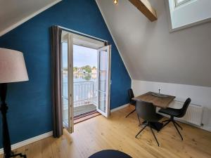 een eetkamer met een tafel en een groot raam bij Sunset Penthouse in Sønderborg