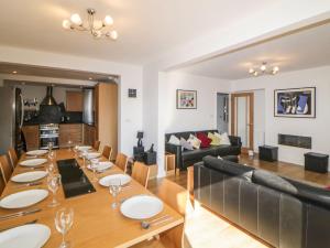 a dining room and living room with a long wooden table at Estuary View in Plymouth