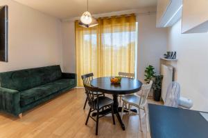 salon ze stołem i zieloną kanapą w obiekcie FIRST -- Green Żoliborz Apartment 2 w Warszawie