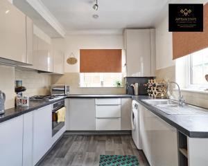 una cocina con armarios blancos y fregadero en Vintage Vibes By Artisan Stays in Southend-On-Sea I Free Parking I Weekly or Monthly Stay Offer I Sleeps 5 en Southend-on-Sea