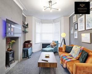 a living room with a couch and a tv at Vintage Vibes By Artisan Stays in Southend-On-Sea I Free Parking I Weekly & Monthly Stay Offer in Southend-on-Sea