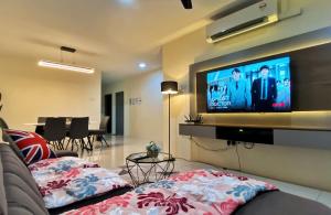 a living room with a couch and a flat screen tv at Comfy PoolView@Ipoh Waterpark Netflix(Wifi) in Ipoh