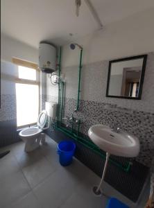 a bathroom with a sink and a toilet and a mirror at KC Homestay in Sissu