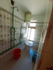 a bathroom with a toilet and a window at KC Homestay in Sissu