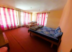 a bedroom with a bed in a room with windows at KC Homestay in Sissu