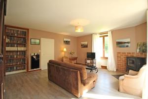 uma sala de estar com um sofá e uma lareira em Les grangettes em Rilhac-Rancon