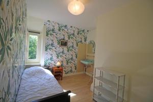 um pequeno quarto com uma cama e uma janela em Les grangettes em Rilhac-Rancon