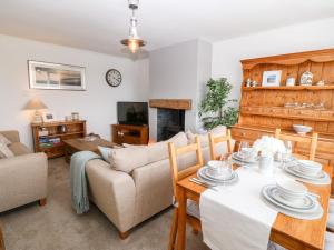 ein Wohnzimmer mit einem Tisch und einem Sofa in der Unterkunft Valley Pines in Holyhead