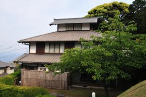 une maison avec une clôture devant elle dans l'établissement Yokohama Fujiyoshi Izuten, à Itō