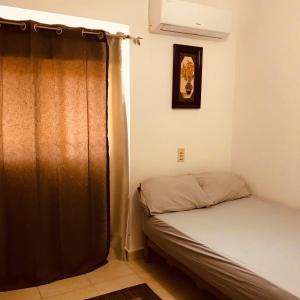 a small bedroom with a bed and a curtain at Chalet Marina Wadi Degla Families Only Pool view 2nd floor with Roof 6 adults in Ain Sokhna +38 photos