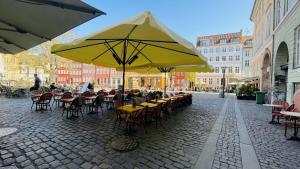 a group of tables and chairs under a yellow umbrella at ApartmentInCopenhagen Apartment 1538 in Copenhagen