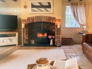 a living room with a fireplace and a television at Old Church Farm in Hinstock