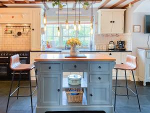 a kitchen with a island with a vase of flowers on it at Old Church Farm in Hinstock +17 photos