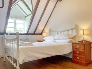a bedroom with a white bed and a window at Old Church Farm in Hinstock