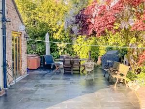 eine Terrasse mit Tischen, Stühlen und Bäumen in der Unterkunft Old Church Farm in Hinstock