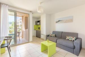 uma sala de estar com um sofá e uma mesa em Appart'City Confort La Ciotat - Côté Port em La Ciotat