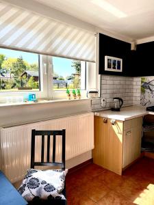 a kitchen with a chair in front of a window at FeWo Sunshine in Heringsdorf