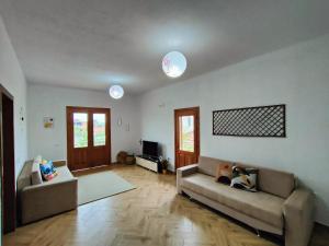 sala de estar con 2 sofás y TV en Villa Apollonia Guest House, en Fier