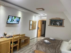 a bedroom with a bed and a desk and a table at Rustic Inn River in Plitvička Jezera